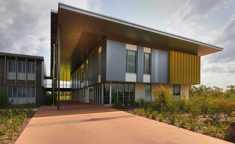 Cantilevered roofs sitting lantern-like atop the weightiness of a concrete block work-base, MacKillop Catholic College in the Northern Territory, roofing, wall cladding, soffits and flashing made from COLORBOND® steel in the colours Windspray®, Jasper®, and Shale Grey™