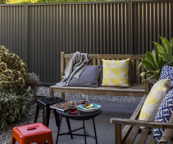 Fencing made from COLORBOND® steel with a garden bench and stools